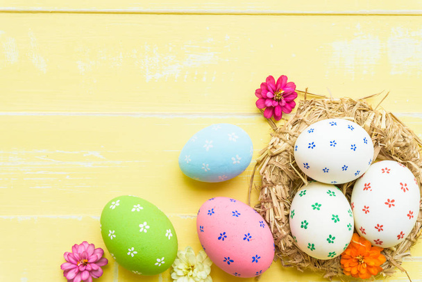 Счастливой Пасхи! Цветные пасхальные яйца в гнезде с красной лентой
 - Фото, изображение