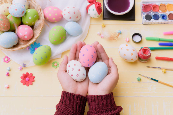 ¡Feliz Pascua! Una mano de mujer sosteniendo para pintar huevos de Pascua
.  - Foto, imagen