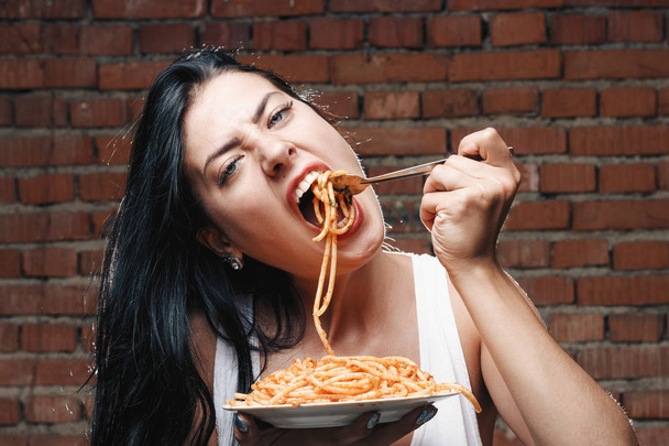 Sexy seductive girl in white T-shirt with plate of pasta and ket - Photo, Image