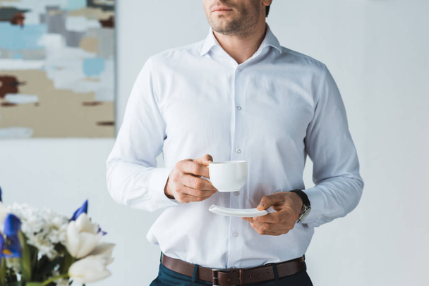 Close-up view of businessman drinking coffee in office - Photo, image