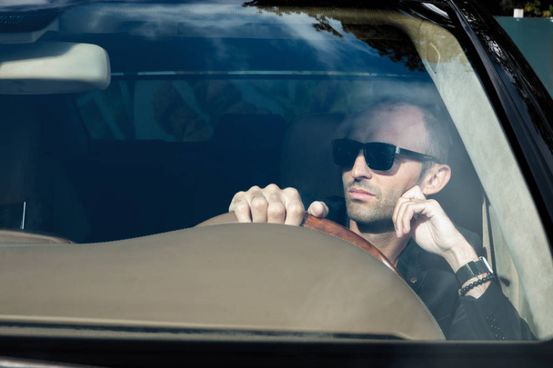 Stylish man in suit in black car. Business Man in glasses sittin - Zdjęcie, obraz