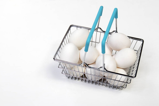 the Shopping Basket With blue Handle and white eggs - Foto, afbeelding