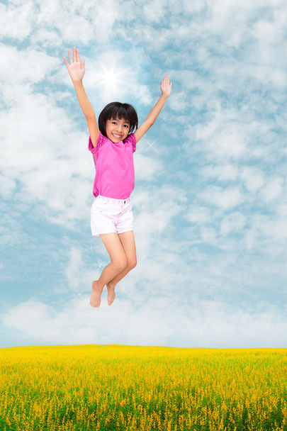 Little girl jumping against beautiful sky - Photo, Image