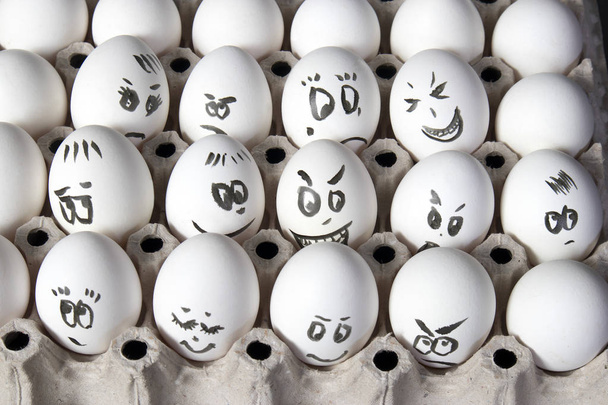 the Hen eggs in box. Eggs cover with drawings. Look like man face - Foto, Imagem