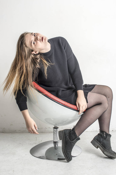 Young beautiful girl sitting in a gray long warm sweater - Foto, Imagen