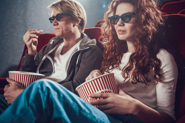 Guy and woman are sitting and watching a movie - Foto, Bild