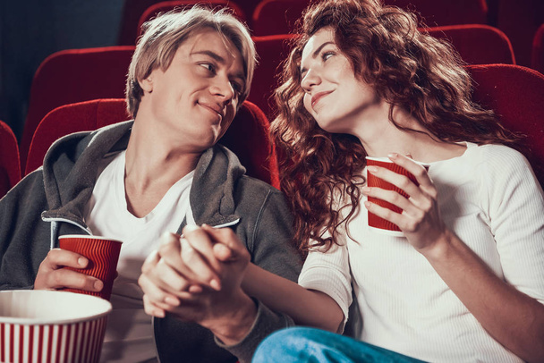 Guy and woman are sitting and watching a movie - Foto, imagen