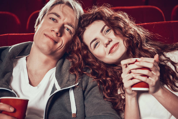 Guy and woman are sitting and watching a movie - Photo, Image