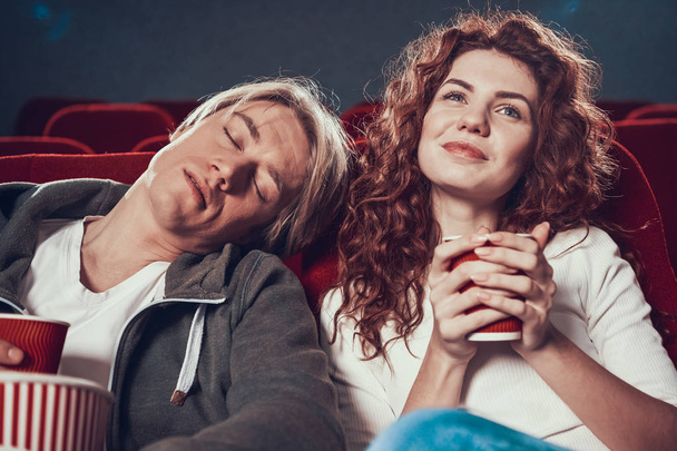 Guy and woman are sitting and watching a movie - Φωτογραφία, εικόνα