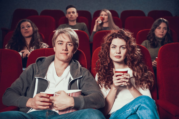 People sit in the cinema and watch movie together. - Фото, изображение