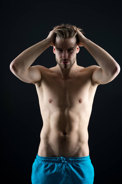 Strong athletic man fitness model torso showing six pack abs on black background - Fotó, kép