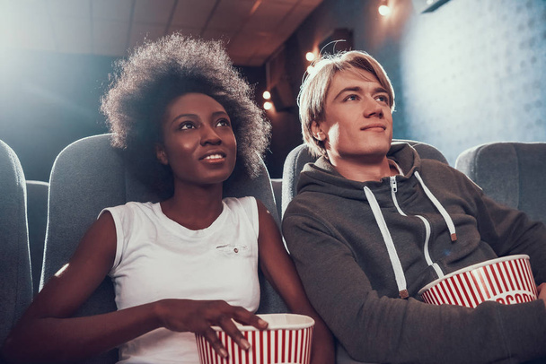 Multinational couple is watching comedy in cinema. - 写真・画像