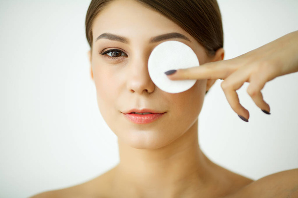 Hautpflege. junge Frau mit Lotion wäscht Gesicht im Badezimmer - Foto, Bild
