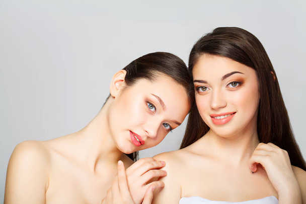 Two beautiful sexy women what posing in studio and holding cream - Photo, image
