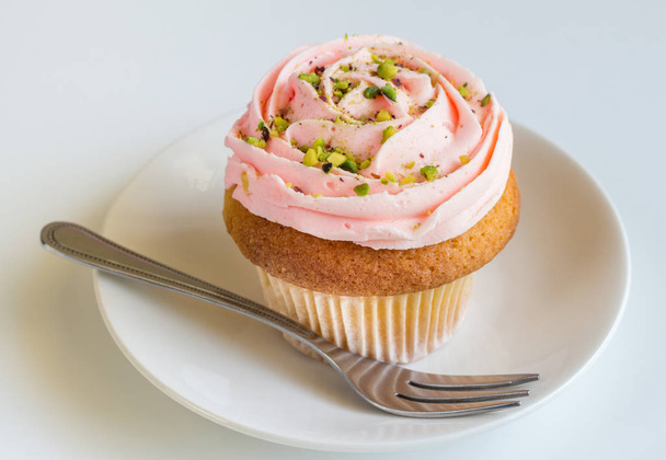 ピンクのバラが白いれたら上 buttercream バニラ カップ ケーキを渦巻いた - 写真・画像