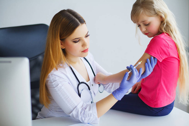 Pediatra. Menina corajosa recebendo injeção
 - Foto, Imagem