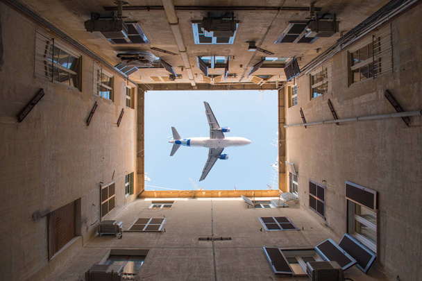 Letadlo letící nad nádvoří dobře bytového domu v Římě. - Fotografie, Obrázek