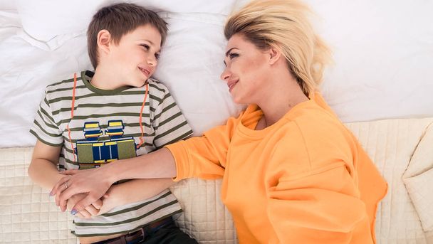 Mother with son on bed, mother and son having fun - Fotó, kép