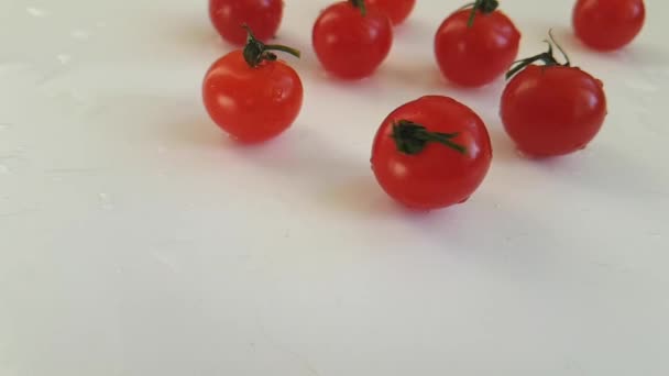 tomates cherry sobre un fondo blanco girando, disparos en cámara lenta
 - Metraje, vídeo