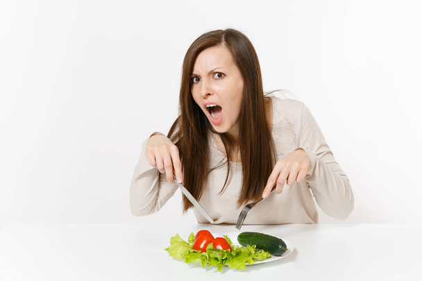 Donna vegana a tavola con foglie di insalata lattuga, verdure su piatto isolato su sfondo bianco. Una corretta alimentazione, cibo vegetariano, stile di vita sano concetto di dieta. Area pubblicitaria con spazio di copia
 - Foto, immagini