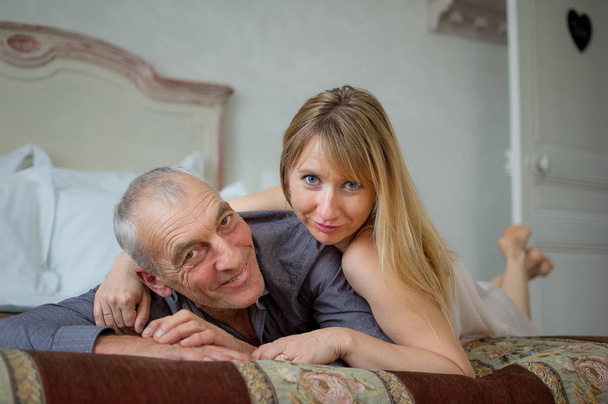 Intérieur Portrait de couple avec différence d'âge couché dans le lit
. - Photo, image