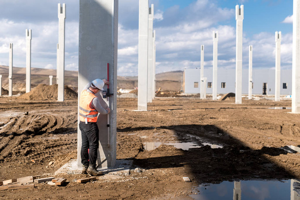 Endüstriyel inşaat mühendisi şantiye çalışma. Profesyonel surveyor seviyesi ölçümü - Fotoğraf, Görsel