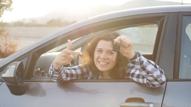 Mujer joven sosteniendo la llave de un coche nuevo
 - Metraje, vídeo