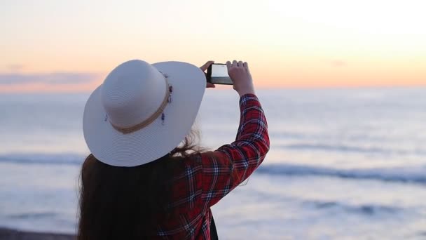 Młoda kobieta robienia zdjęć na plaży podczas Wschodu i zachodu - Materiał filmowy, wideo