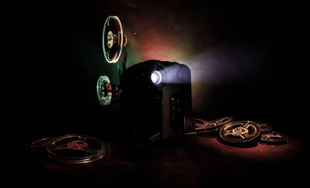 Projector de cinema de estilo antigo, close-up. Projetor de filme em um fundo de madeira com iluminação dramática e foco seletivo. Filmes e conceito de entretenimento
 - Foto, Imagem