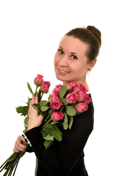 Portrait of middle-aged woman with large flowers of pink color roses and enigmatic look on a white background - Photo, Image