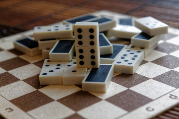 Montón caótico de piezas de dominó sobre el fondo de mesa de madera marrón bambú
 - Foto, Imagen