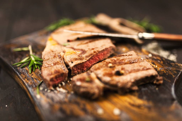 Grilled steak on wooden cutting board - 写真・画像