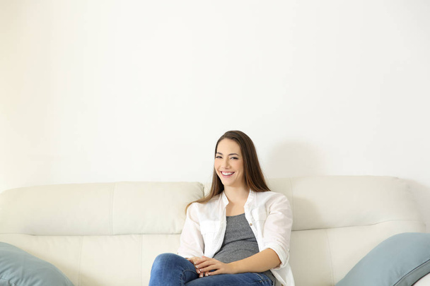 Homeowner sitting on a couch looking at camera - Photo, image