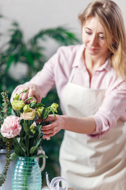 Photo of florist woman with vase and bouquet of flowers - Fotó, kép