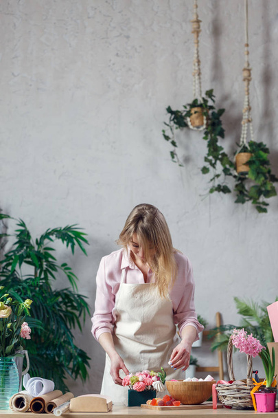 Nainen kukkakauppa tekee mukava kukkakimppu omassa kukkakauppa
 - Valokuva, kuva