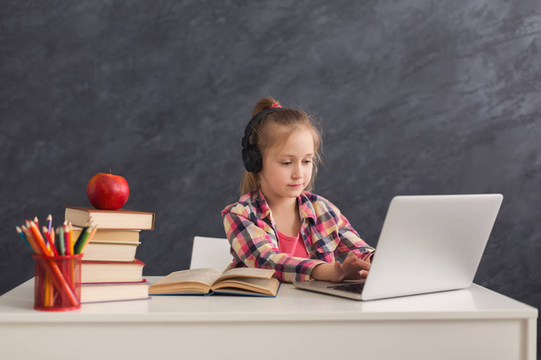 Nettes kleines Mädchen macht Hausaufgaben auf Laptop - Foto, Bild