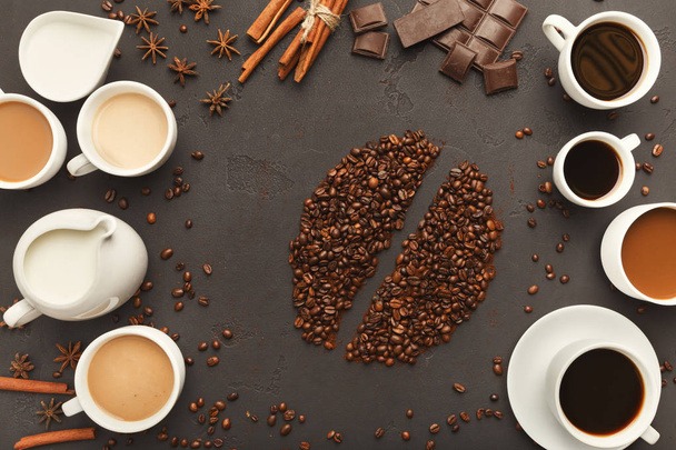 Top view on various coffee cups, scattered beans and spices, background with copy space - Photo, Image