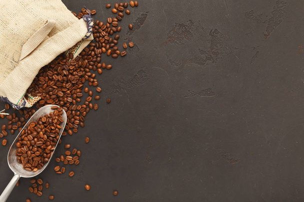 Kávová zrna rozptyl od pytli na šedém pozadí, kopírování prostor - Fotografie, Obrázek