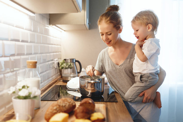 preparation of family breakfast. mother and baby son cook porrid - Фото, изображение