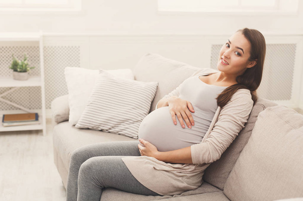 Улыбающаяся беременная женщина мечтает о ребенке
 - Фото, изображение