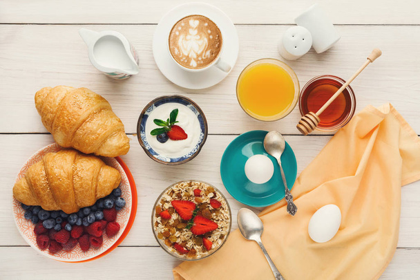 Menu de pequeno-almoço continental na mesa arborizada
 - Foto, Imagem