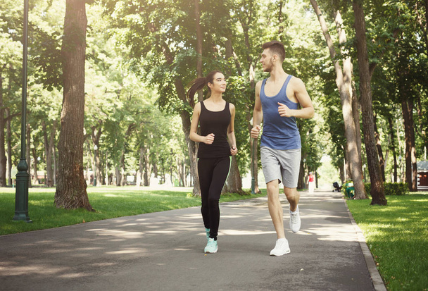 Giovane coppia che fa jogging nel parco verde, copia spazio
 - Foto, immagini