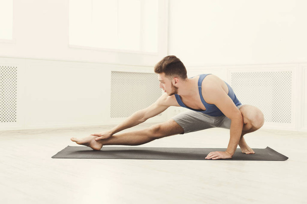 Man stretching at white background indoors - Foto, imagen