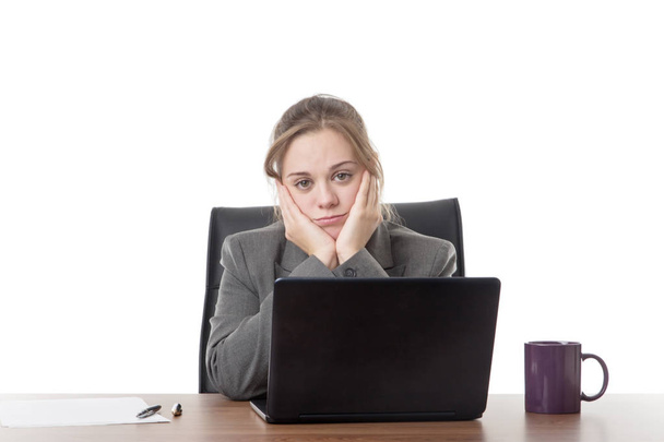 επιχειρήσεων γυναίκα κάθεται σε ένα γραφείο με ένα φορητό υπολογιστή μπροστά της  - Φωτογραφία, εικόνα