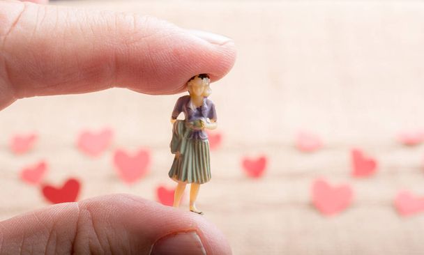 Woman figurine and Love concept with paper heart on  threads - Photo, Image