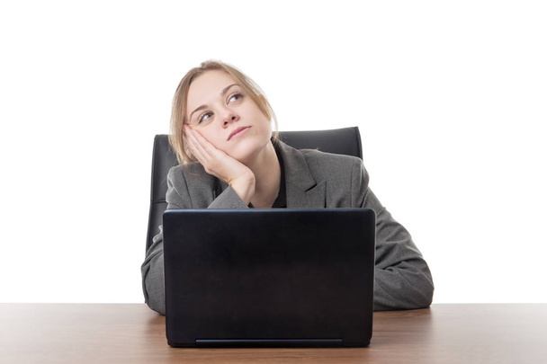 mujer de negocios sentada en un escritorio con una computadora portátil frente a ella
  - Foto, Imagen