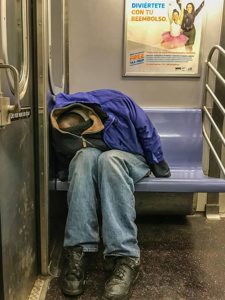 Manhattan, NY US - February 26, 2018 Homeless person sleeps in a subway car - Фото, изображение