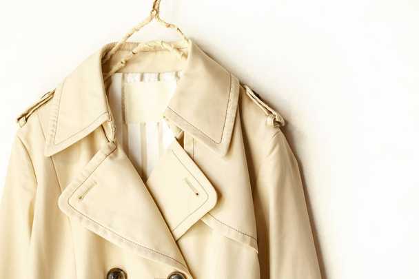 Beige elegant trench coat isolated over white - 写真・画像