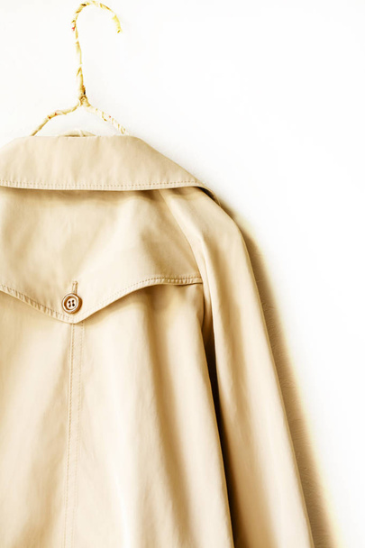 the back of a beige elegant trench coat isolated over white - 写真・画像
