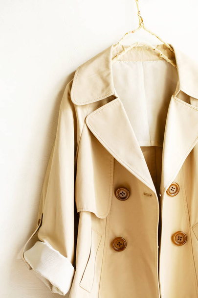 Beige elegant trench coat isolated over white - 写真・画像